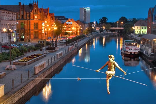 immagine della città di Bydgoszcz di notte. Fiume, statua di funambolo, granai